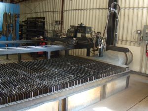 Plasma cutting table equipped with a dust collection system that includes a spark arrestor and flame-retardant media.